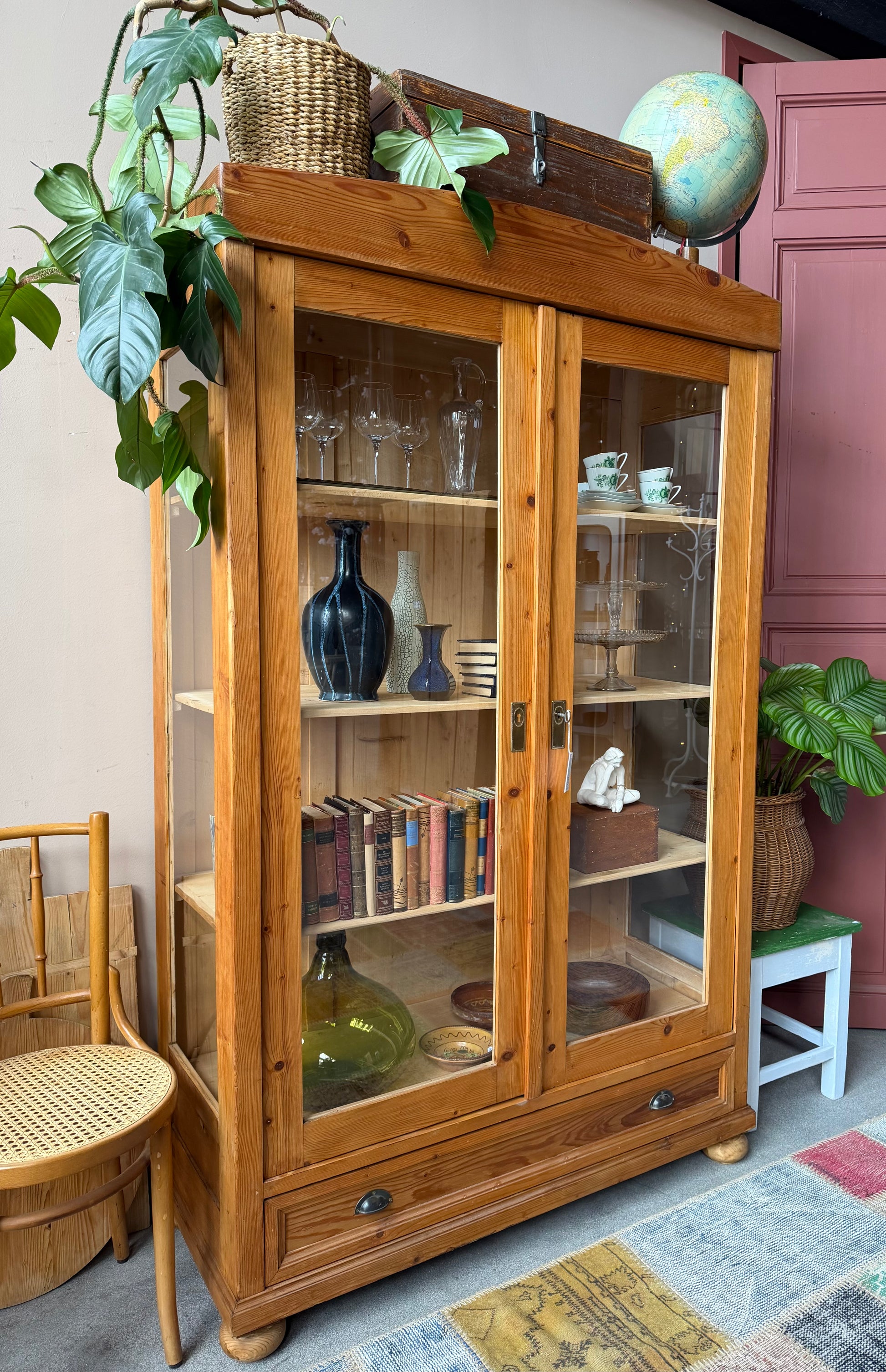 Ett gammalt, elegant vitrinskåp i ljus nyans. Skåpet har två stora vitrindörrar samt glas i sidan för vackert ljusinsläpp. Det har 3 nya och fräscha hyllplan. Det är varsamt renoverat och slutligen bestruken med en vax för skydd och fin yta.
