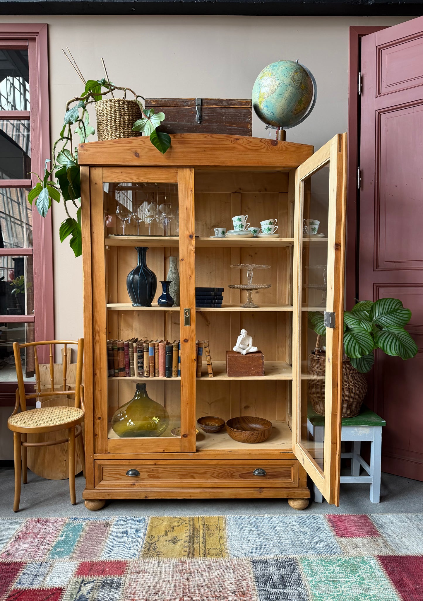 Ett gammalt, elegant vitrinskåp i ljus nyans. Skåpet har två stora vitrindörrar samt glas i sidan för vackert ljusinsläpp. Det har 3 nya och fräscha hyllplan. Det är varsamt renoverat och slutligen bestruken med en vax för skydd och fin yta.