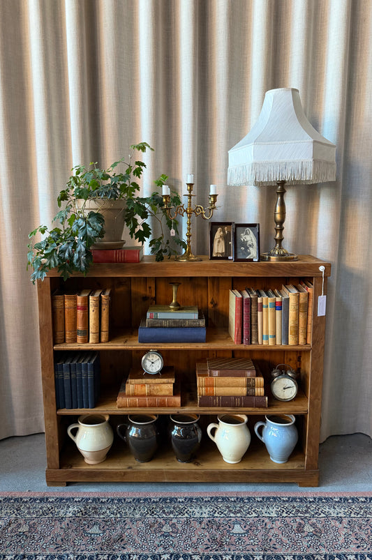 En gammal, vacker bokhylla i trä med två hyllplan. 