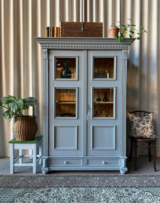 Ett gammalt vitrinskåp med många vackra detaljer. Skåpet har glas i de två översta speglarna samt samt vitrin även på sidorna för ett vackert ljusinsläpp och fin exponering i skåpet. 