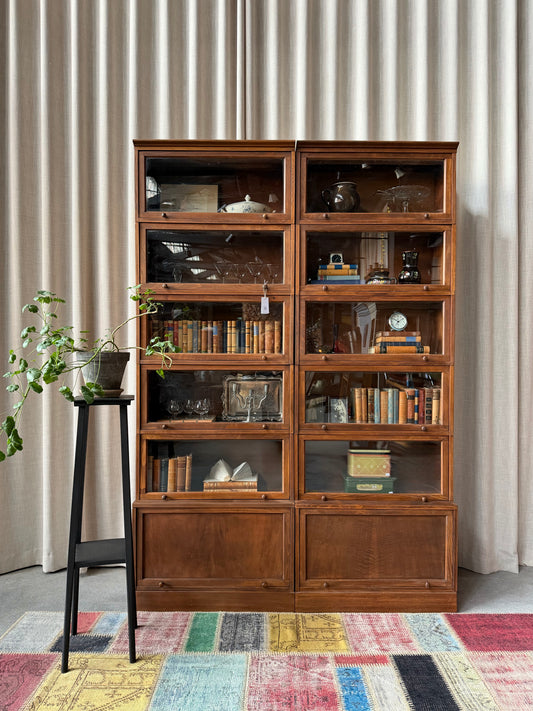 Två gamla, vackra bokskåp med vaxad yta som passar fantastiskt fint tillsammans. Med sitt nätta djup passar dem till så mycket mer än böcker. Kanske som vitrinskåp i köket, eller fylld med personliga ting i vardagsrummet. Skåpen säljs tillsammans i två sektioner. 