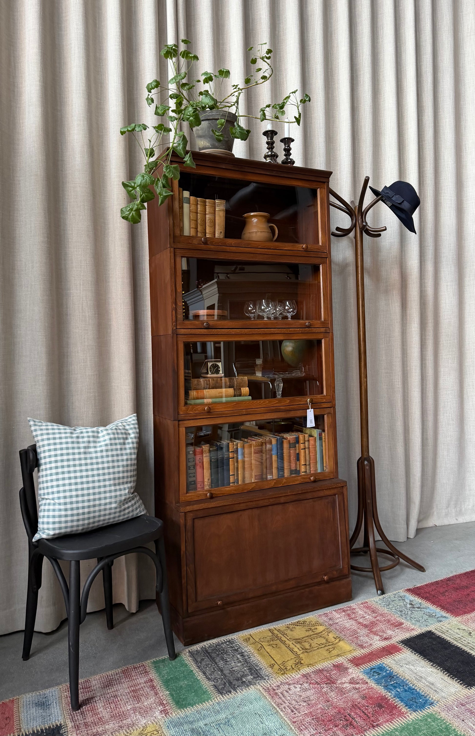 Ett gammalt, vackert bokskåp med vitrin och ett täckt skåp nedtill. Med sitt nätta djup och praktiska bredd passar det till så mycket mer än böcker. Kanske som vitrinskåp i köket, eller för de fina flaskorna i badrummet?Skåpet levereras i delar (sockel, 5 skåp och krön) och sätts enkelt ihop.