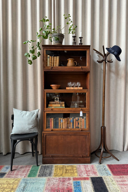 Ett gammalt, vackert bokskåp med vitrin och ett täckt skåp nedtill. Med sitt nätta djup och praktiska bredd passar det till så mycket mer än böcker. Kanske som vitrinskåp i köket, eller för de fina flaskorna i badrummet?Skåpet levereras i delar (sockel, 5 skåp och krön) och sätts enkelt ihop.