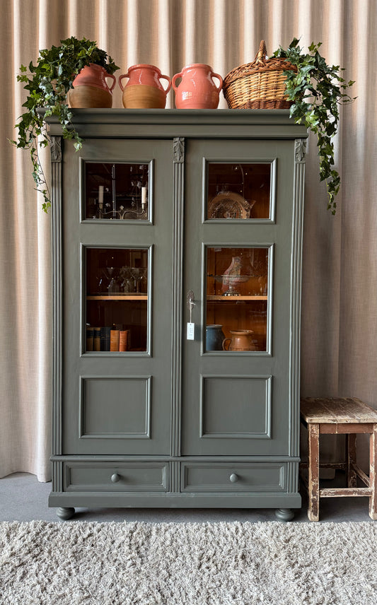 Ett vackert gammalt vitrinskåp med klassiska former och fina detaljer. Då skåpet har både vitringlas och dold förvaring blir denna möbel både vacker och praktisk.