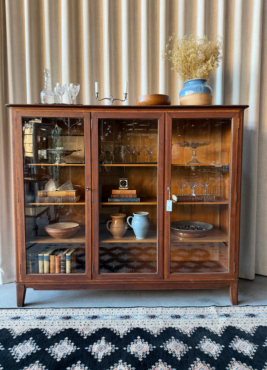 En gammal, fin och elegant skänk med tre vitrindörrar.