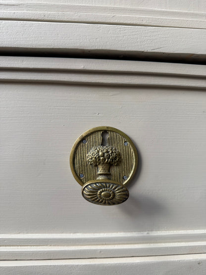 Ett gammalt fantastiskt vackert vitrinskåp med tre dörrar med vitringlas och två lådor. Skåpet har många fina arbetade detaljer såsom utsmyckat krön som en korg fylld med blommor och rundade mjuka former både på krönet och i vitringlaset. Skåpet är även utsmyckat med charmiga och vackra beslag i original. 