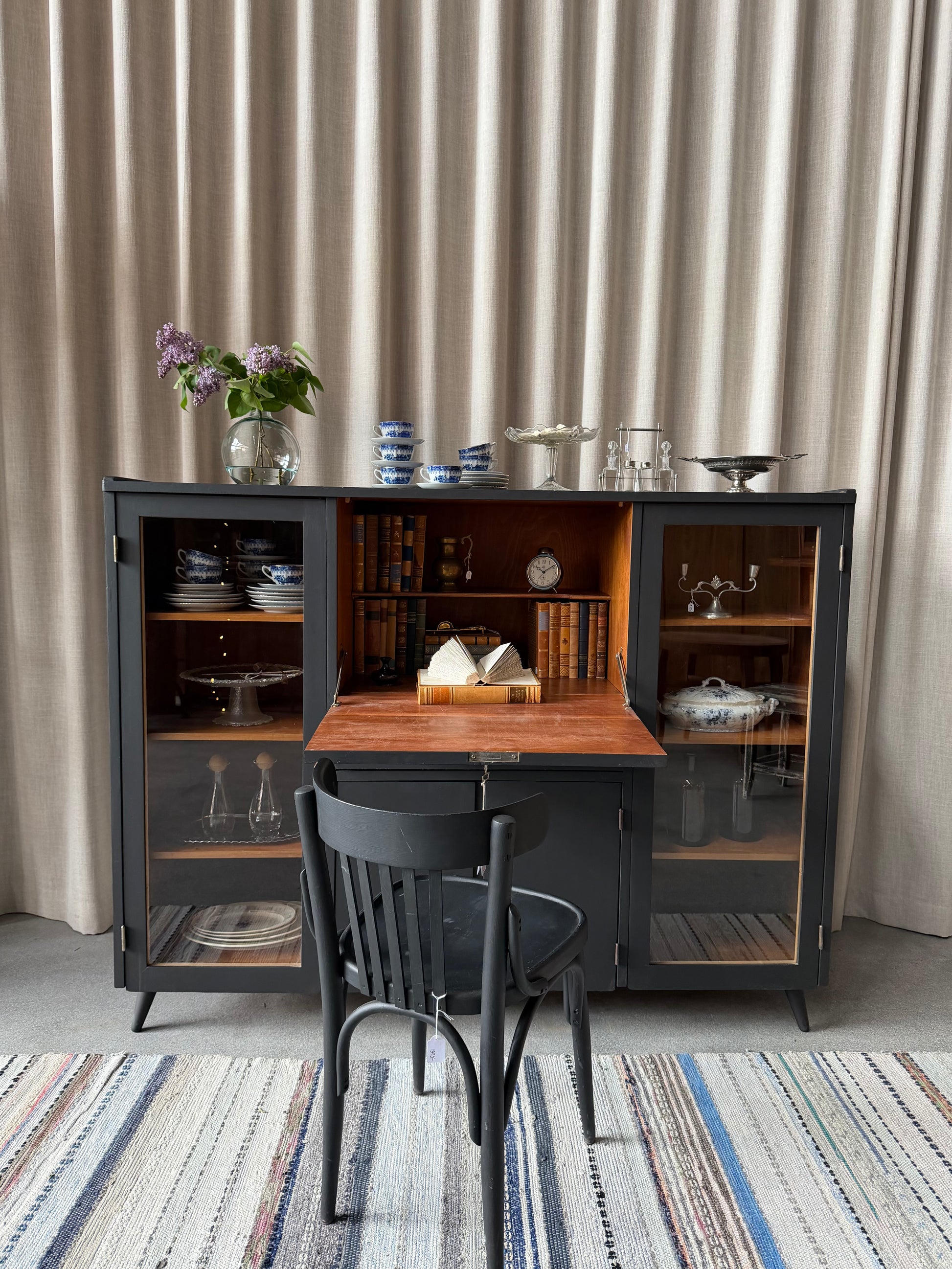 En gammal, elegant möbel som kan användas som skänk/sekretär/vitrinskåp. Perfekt för dig som önskar en både praktisk, elegant och otroligt charmig möbel där du kan "gömma undan" datorn i sekretären när du arbetat klart. Skåpet har i dagsläget flera hyllplan i vitrindelen samt en hylla i det täckta skåpet nedtill. Det finns även en liten låda. 