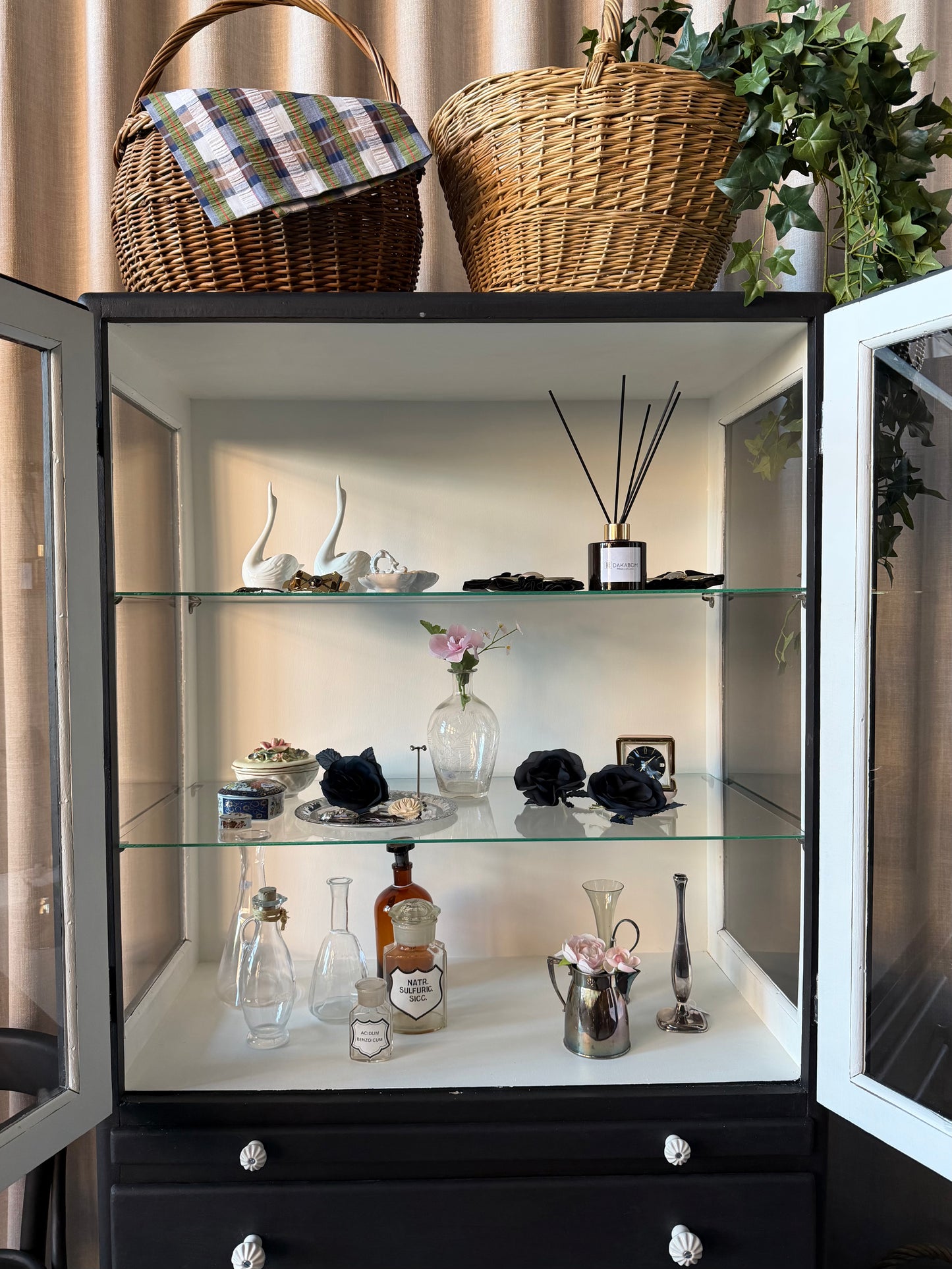 Ett gammalt läckert vitrinskåp/läkarskåp i trä med två hyllor i glas och även glas i sidan. Ett perfekt skåp för badrummet eller som vitrinskåp i kök eller vardagsrum. Skåpet har både en utdragbar skiva samt fina små lådor och skåp med dold förvaring nertill. Ett väldigt praktiskt skåp helt enkelt. 