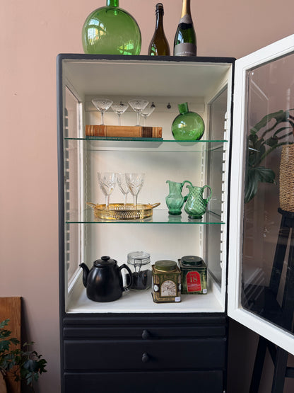Ett gammalt läckert läkarskåp i trä med två hyllor i glas och även glas i sidan. Ett perfekt skåp att ha som vitrinskåp i köket, eller fyll det med dina finaste parfymflaskor och smycken och ha det i badrummet.Skåpet har både en utdragbar skiva samt låda och skåp med dold förvaring nertill. Väldigt praktiskt skåp helt enkelt. 