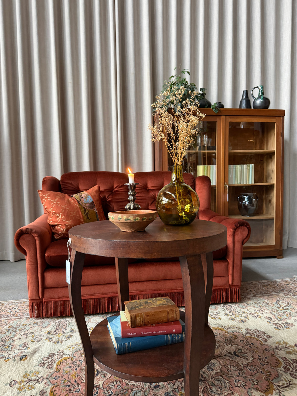 Ett gammalt vackert nätt bord med runda former och ytterligare avställningsyta på en underhylla.