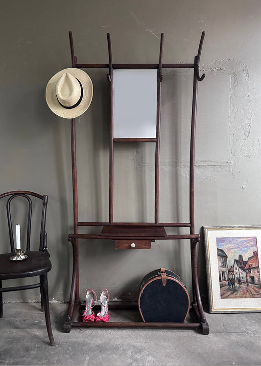 Hallmöbel med hängare, spegel och liten låda i brunt trä. Bild tagen rakt framifrån.