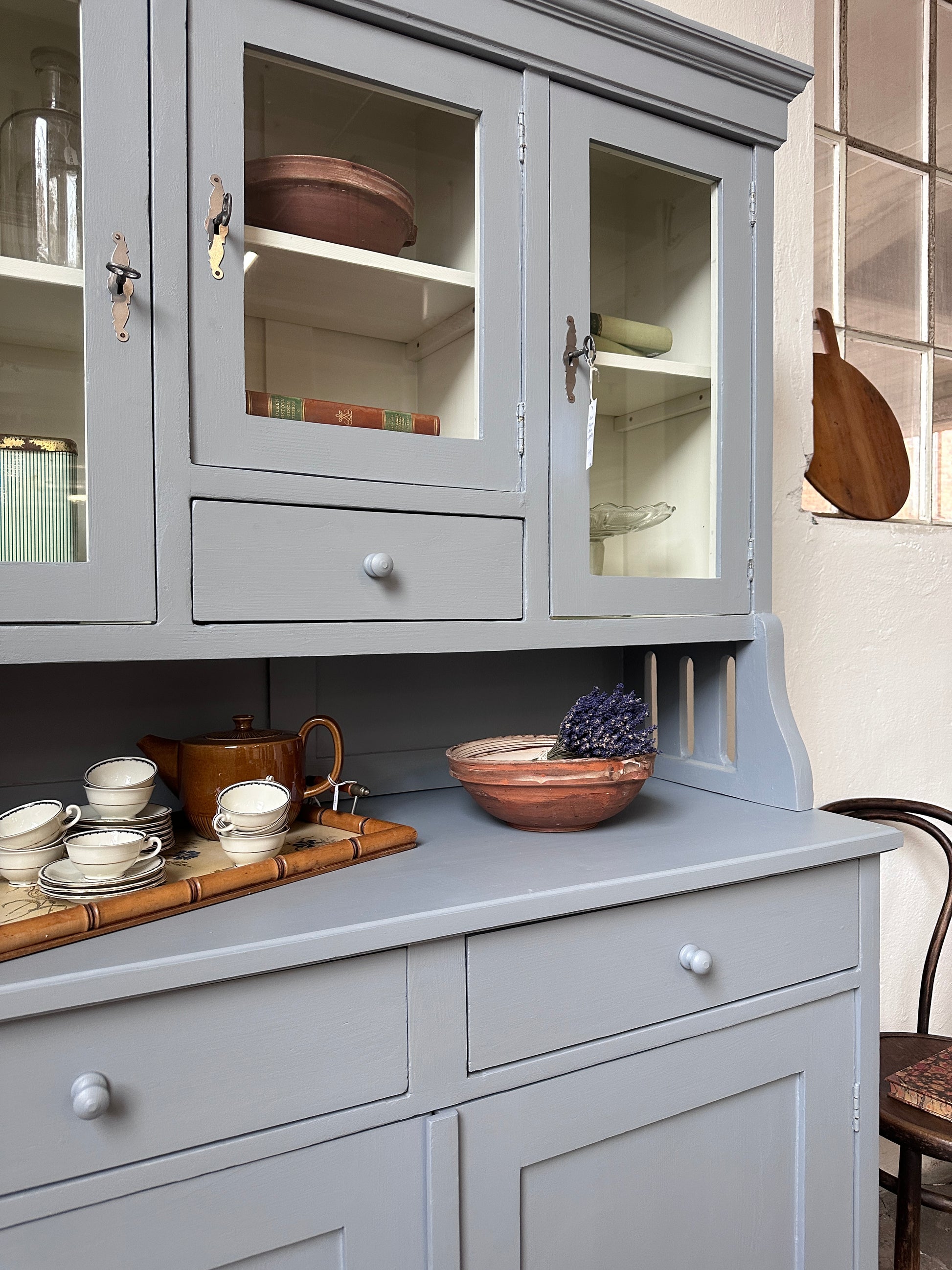 Bild visar ett gråblått köksskåp med vitrinluckor samt täckta luckor och lådor. Bild visar närbild på avställningsyta.