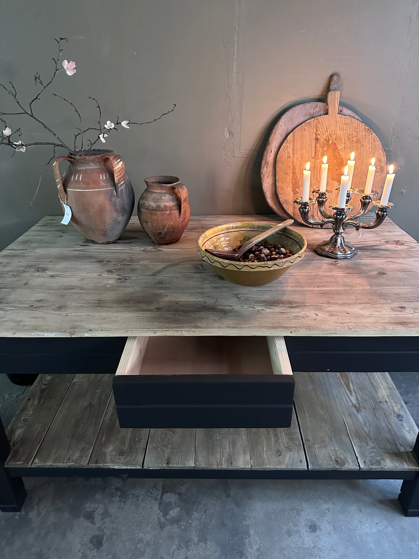Bord/köksö med trären toppskiva samt underhylla. Underredet är målat  med en svart snickerifärg. Bilden är tagen snett uppifrån.