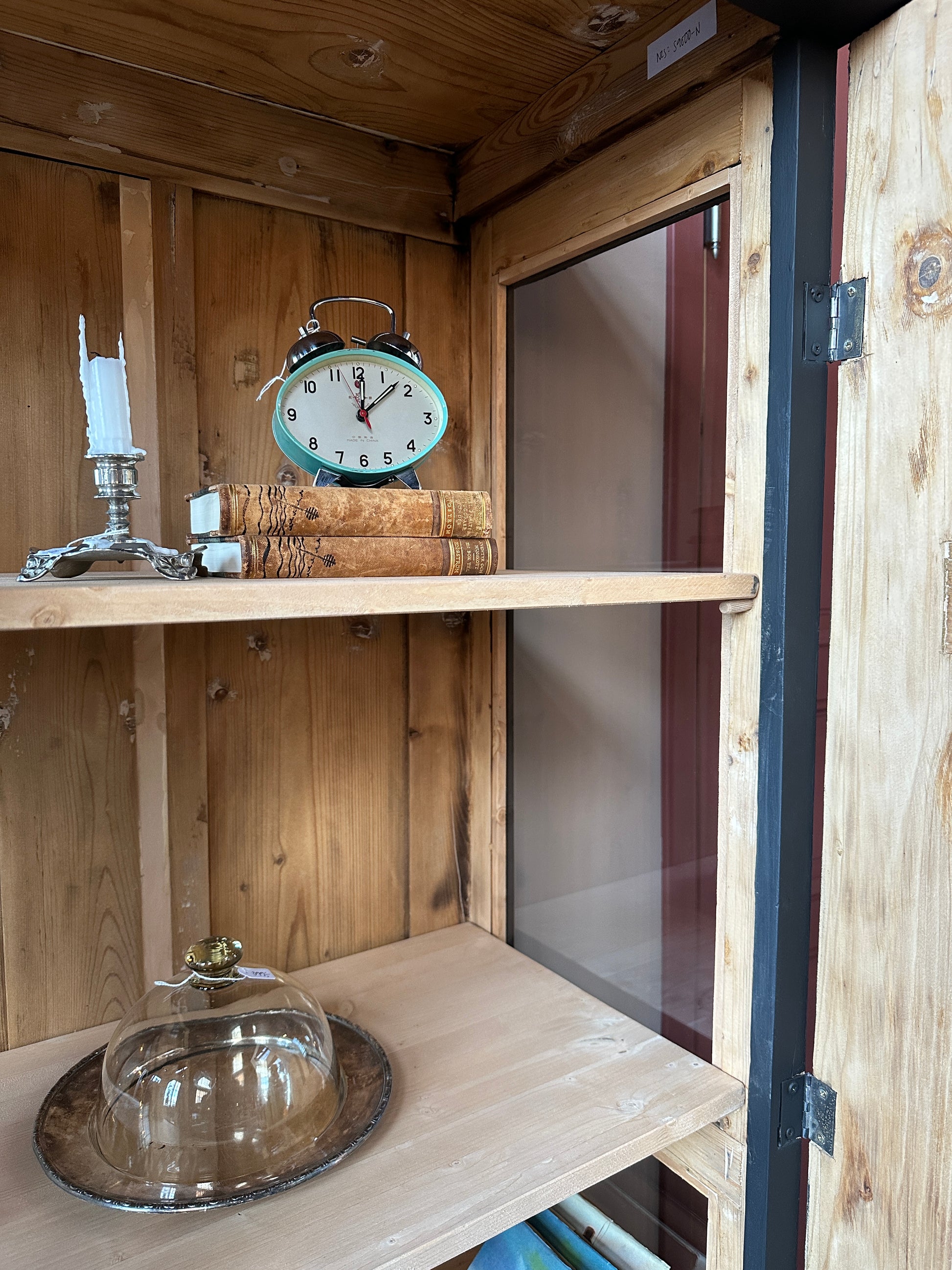 Detaljbild hyllplan i ett vitrinskåp.