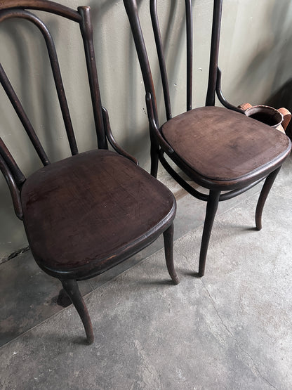 2 st gamla stolar i mörkt trä. Bilden är tagen snett uppifrån.