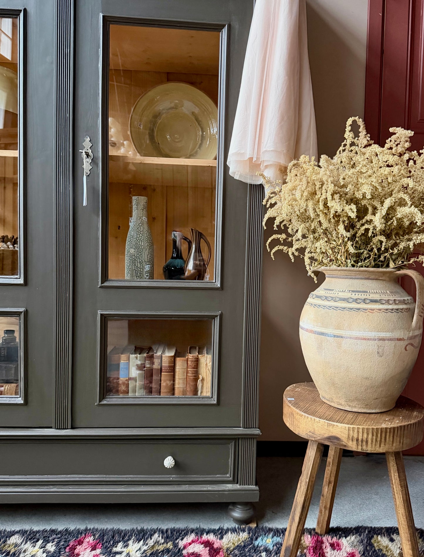 Ett gammalt, fantastiskt vackert vitrinskåp med fina detaljer i de raka formerna och det arbetade krönet. Skåpet har i dagsläget 3 st nya och fräscha hyllplan.Det har dessutom en bred praktisk låda längst ner med vackra porslinsknoppar. Skåpet är varsamt renoverat och slutligen penselmålat med en matt, vattenbaserad snickerifärg i en brun/grå kulör. 